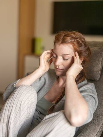 Thoughtful middle-aged woman with long red hair – a moment of self-reflection at Park Igls Medical Spa Resort